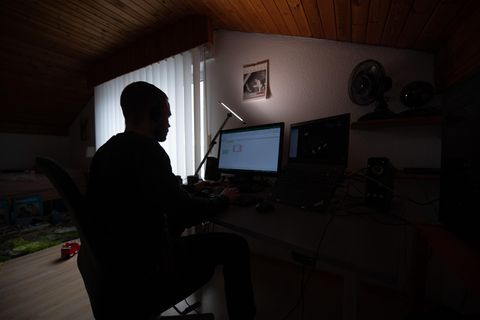 Mann arbeitet in der Dunkelheit vor einem Computer