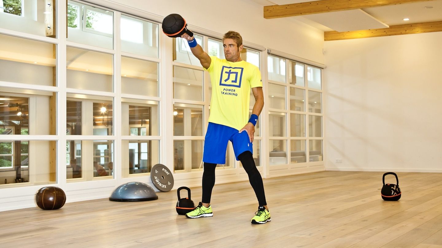Kettlebell Workout: Ex-Triathlon-Profi Max Longrée trainiert mit Kettlebell in einem Fitnessraum