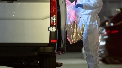 Ein Kriminaltechniker bringt einen Plastikbeutel zum Wagen