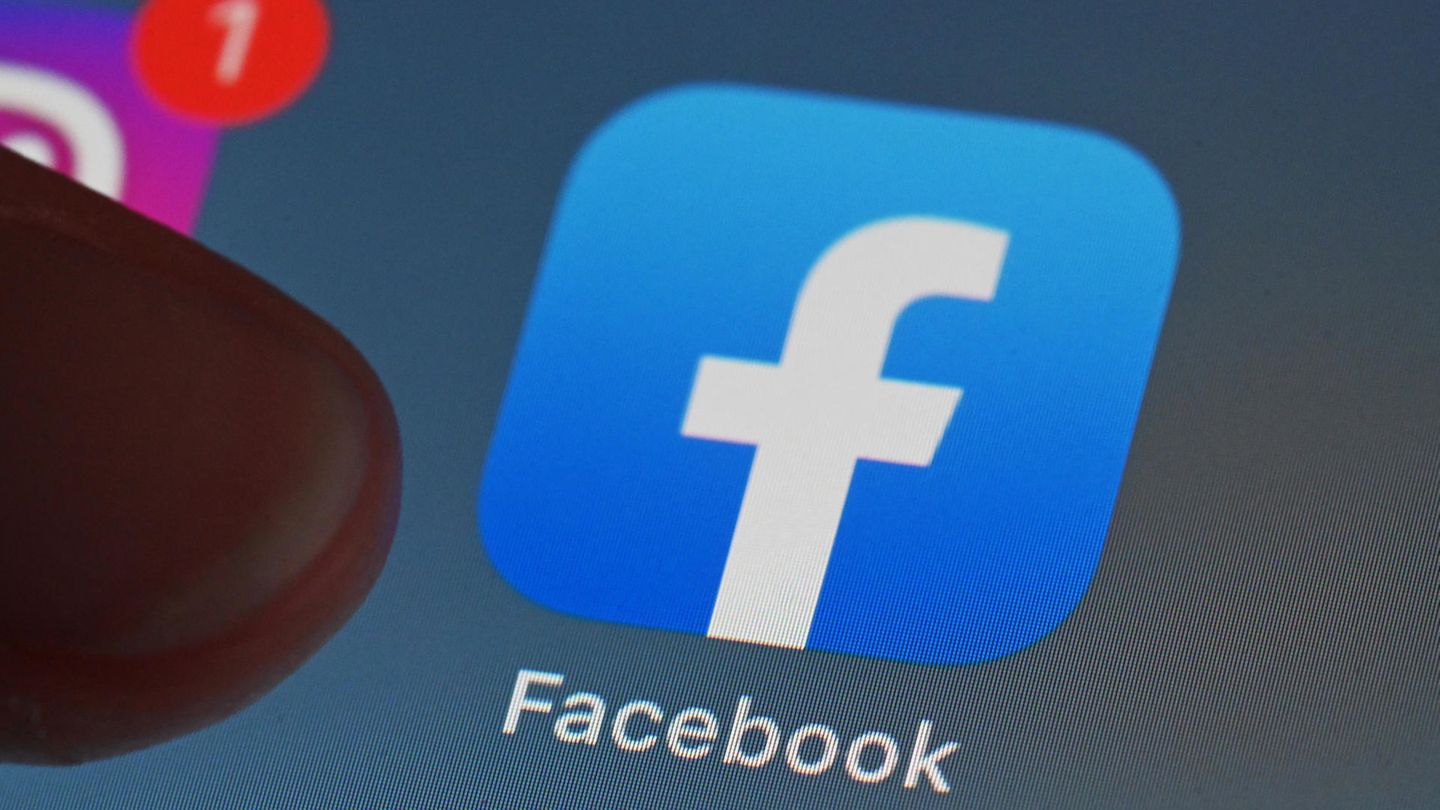 Eine Person zeigt auf einem Tablet auf die Facebook App.