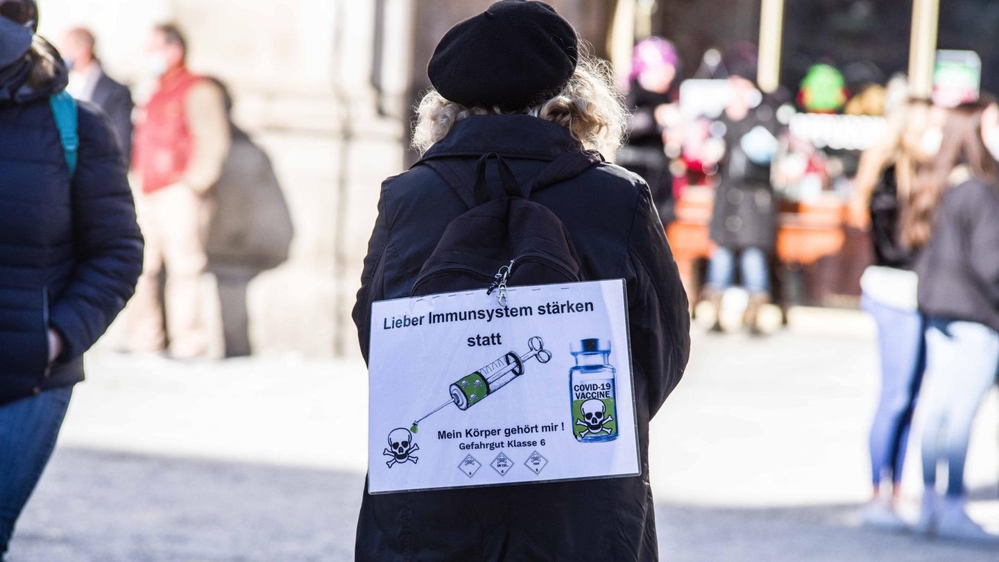 Frau auf einer Impfgegen-Demo, sie trägt ein Plakat auf ihrem Rücken: "Lieber Immunsystem stärken statt impfen" Frau auf einer Impfgegen-Demo, sie trägt ein Plakat auf ihrem Rücken: "Lieber Immunsystem stärken statt impfen"