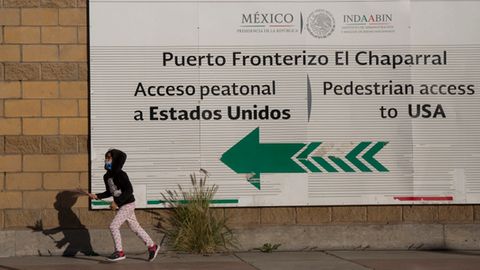 Ein Mädchen spielt, während ihre Eltern am Grenzübergang in Tijuana protestieren