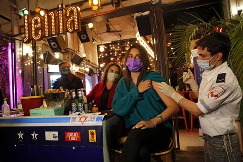 Israel Coronavirus: Eine Frau wird an einem Bar-Tresen gegen das Coronavirus geimpft