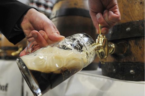 Ein Mann zapft ein Bier aus einem Fass