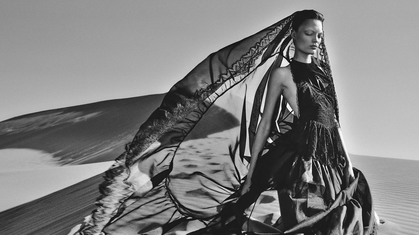 Ein Model trägt ein langes Kleid im Wüstenwind