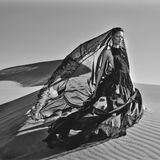 Ein Model trägt ein langes Kleid im Wüstenwind