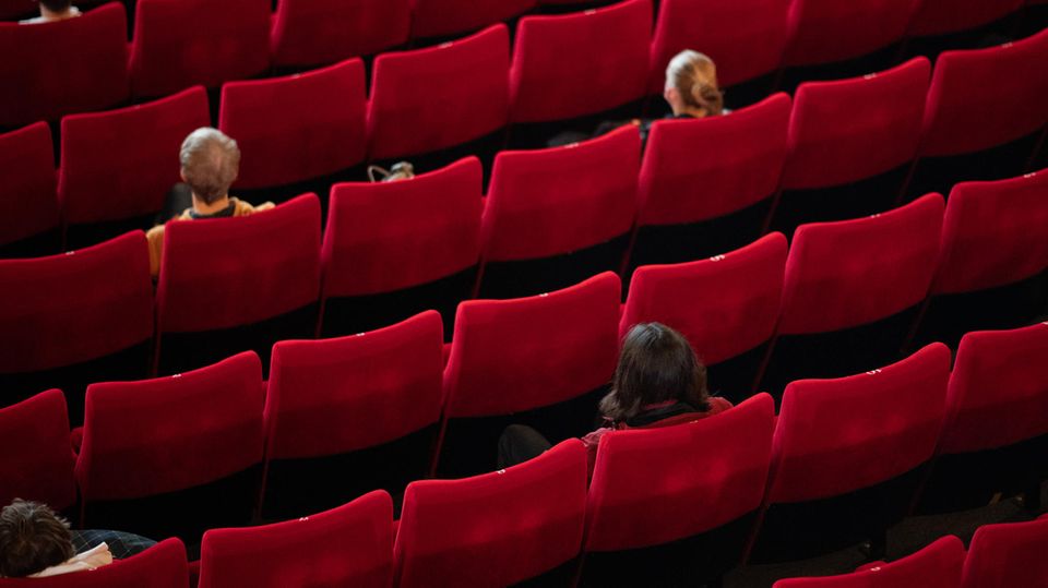 Wenige Besucher sitzen mit weitem Abstand zueinander aufgrund der Corona-Pandemie in einem Kinosaal (Archivfoto)