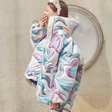 Ein Model trägt eine Daunenjacke mit großem Kragen und hält sich gähnend die Hand vor den Mund