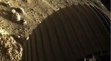 Teil eines Rades des Rovers Perseverance im Mars-Sand