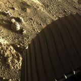 Teil eines Rades des Rovers Perseverance im Mars-Sand