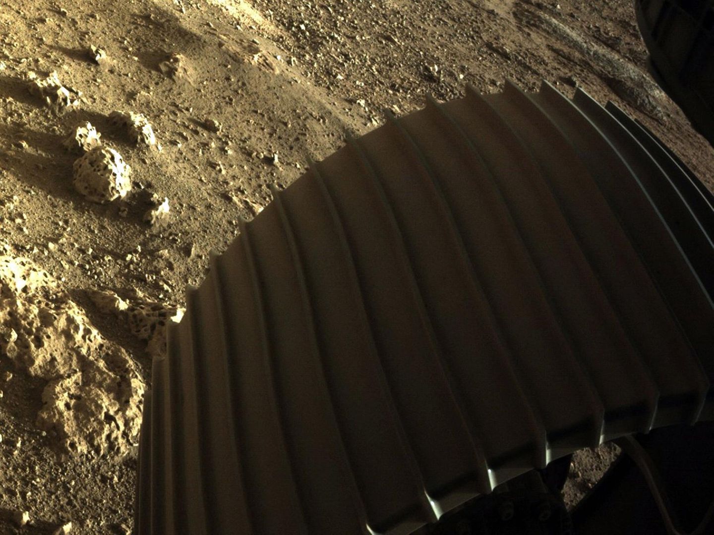 Teil eines Rades des Rovers Perseverance im Mars-Sand