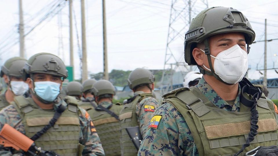 Ecuador Soldaten mit Helmen und Gewehren marschieren in Ecuador auf ein Gefängnis zu, in dem es einen Aufstand gibt