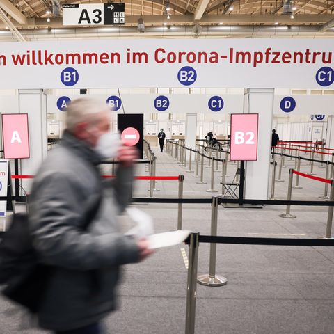 Ein Mann geht durch den Eingang in das Impfzentrum in den Hamburger Messehallen zu seiner Corona-Impfung