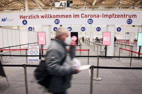 Ein Mann geht durch den Eingang in das Impfzentrum in den Hamburger Messehallen zu seiner Corona-Impfung