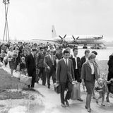 Eine Gruppe Urlauber aus der DDR ist im Juni 1964 mit einem Flug in einer Iljuschin Il-18 aus der Sowjetunion zurückgekehrt und macht sich auf dem Weg ins Flughafengebäude.