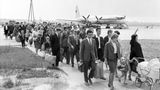 Eine Gruppe Urlauber aus der DDR ist im Juni 1964 mit einem Flug in einer Iljuschin Il-18 aus der Sowjetunion zurückgekehrt und macht sich auf dem Weg ins Flughafengebäude.