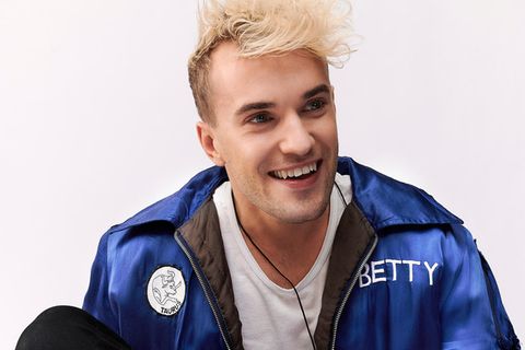 Jendrik Sigwart sitzt bei Fotoaufnahmen in einem Studio auf dem Boden