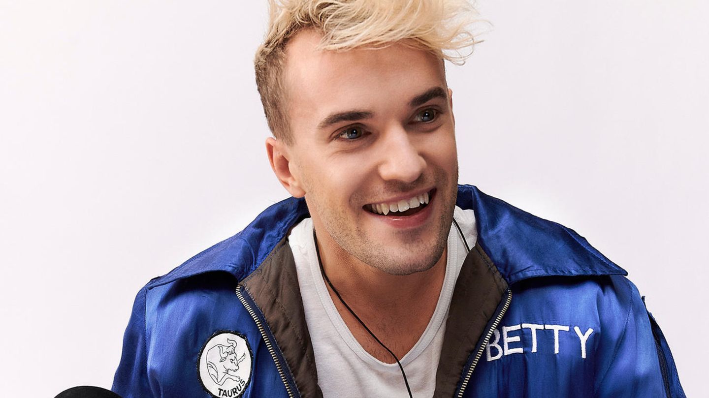 Jendrik Sigwart sitzt bei Fotoaufnahmen in einem Studio auf dem Boden