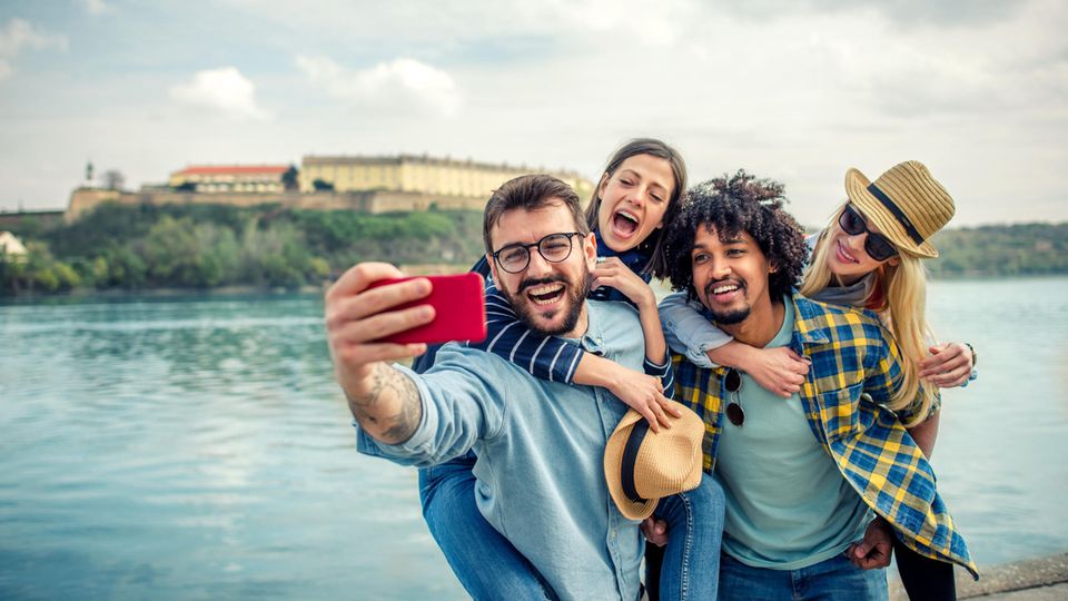 Eine Gruppe junger Menschen macht ein Selfie mit einem Smartphone mit guter Kamera unter 300 Euro.