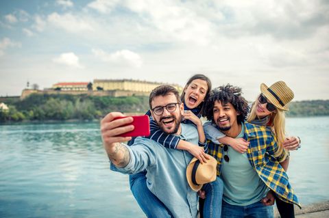 Eine Gruppe junger Menschen macht ein Selfie mit einem Smartphone mit guter Kamera unter 300 Euro.