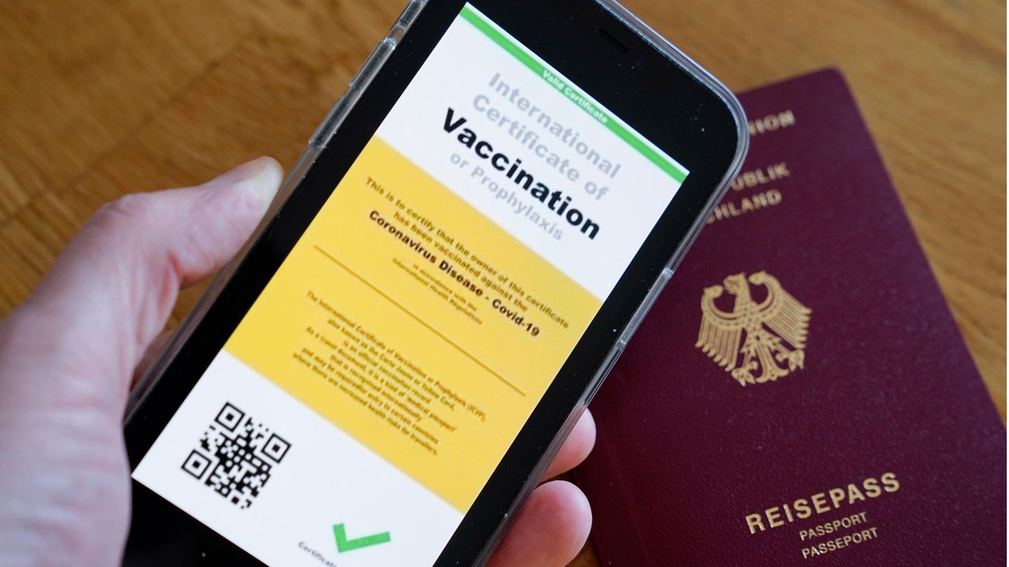 Symbolbild eines möglichen digitalen Impfpasses der Europäischen Union und eines deutschen Reisepasses