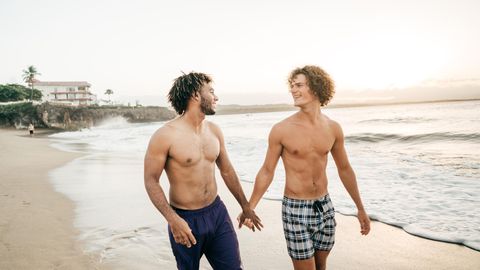Ein schwules Paar spaziert am Strand entlang
