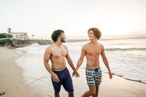 Ein schwules Paar spaziert am Strand entlang
