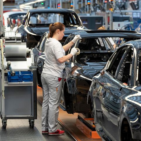 Frau steht bei Audi am Band.