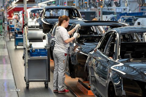 Frau steht bei Audi am Band.