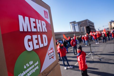 Auf einem Plakat der IG Metall steht während eines Streiks der Schriftzug "Mehr Geld"