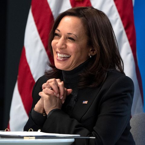 Kamala Harris lächelnd vor US Flagge