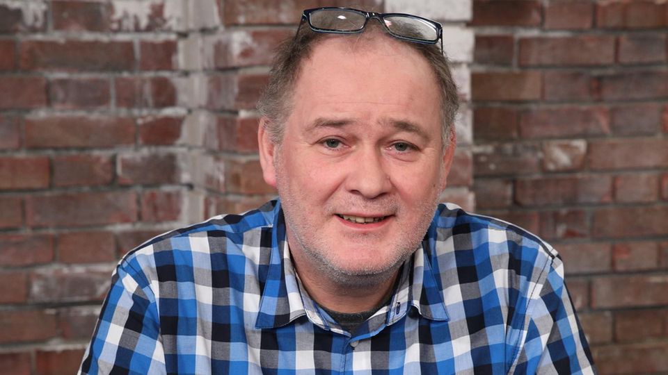 Walter Lehnertz sitzt in einem karierten Hemd im Studio von Bares für Rares