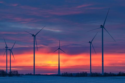 Windkraftanlage in Schleswig-Holstein vor einem Sonnenuntergang.