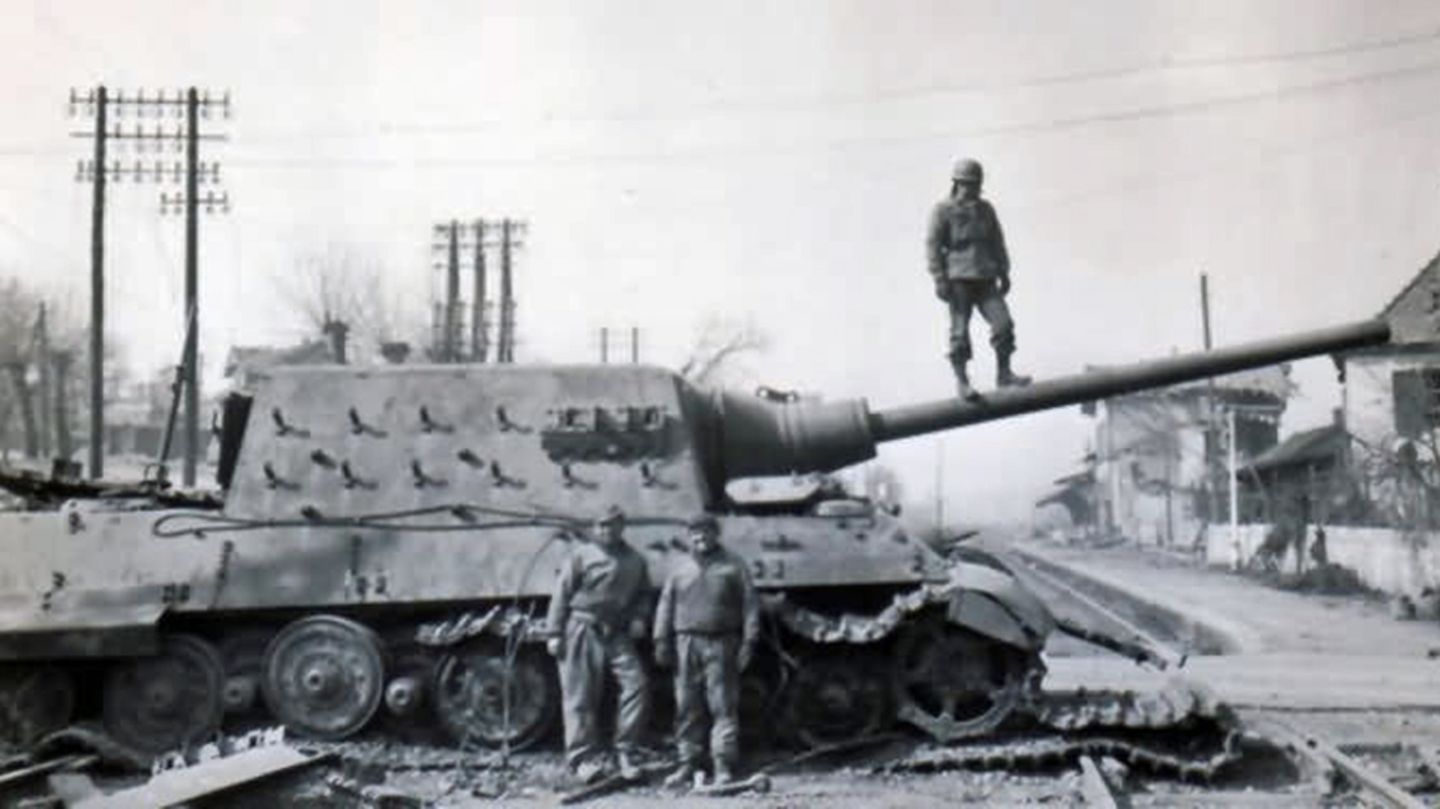 Alliierte Soldaten neben einem liegengebliebenen Jagdtiger.
