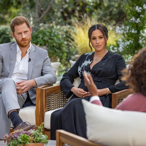 Herzogin Meghan und Prinz Harry sitzen im Garten und schauen Oprah Winfrey an.