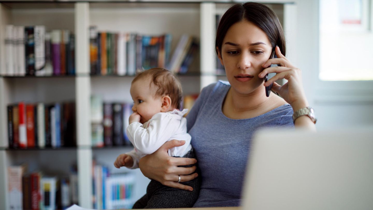 Junge Mutter arbeitet mit Baby