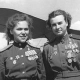 Zwei dekorierte Pilotinnen vor ihren Doppeldeckern.