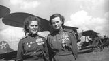 Zwei dekorierte Pilotinnen vor ihren Doppeldeckern.