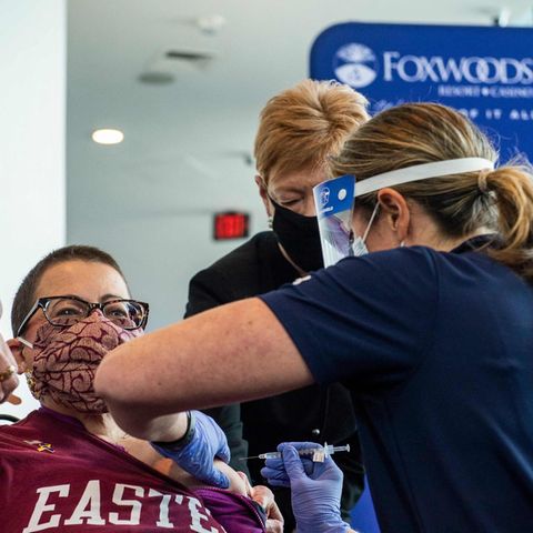 Eine Frau zeigt Damen hoch während sie in Connecticut gegen Corona geimpft wird