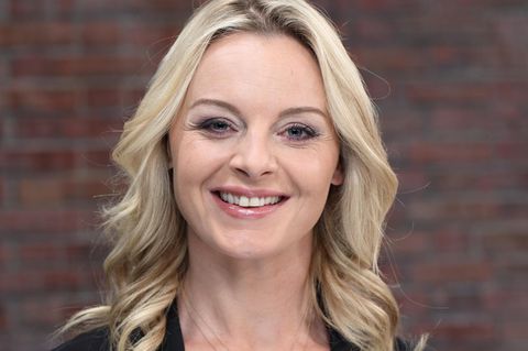 Susanne Steiger steht im Bares für Rares Studio in Pulheim und lächelt in die Kamera