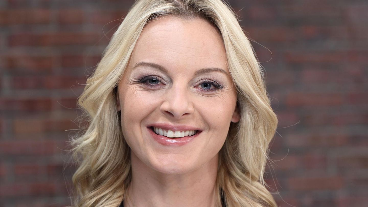 Susanne Steiger steht im Bares für Rares Studio in Pulheim und lächelt in die Kamera