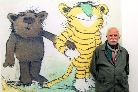 Autor und Illustrator Janosch steht vor seiner Zeichnung bei einer Ausstellung.
