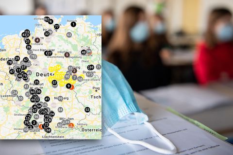 Schülerinnen und Schüler sitzen mit Mund- und Nasenschutz in einem Klassenraum