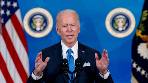Joe Biden steht am Pult mit dem Wappen des US-Präsidenten. Hinter ihm eine blaue Wand mit weißem "Covid-19 Response"-Schriftzug