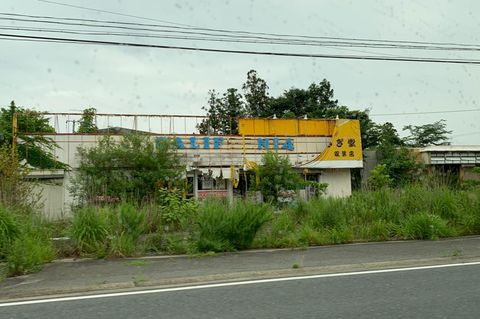Ein zerstörtes Geschäft am Straßenrand in Fukushima