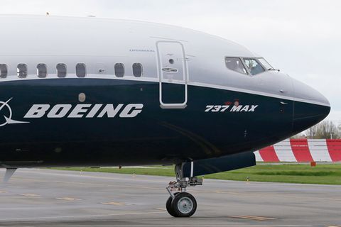 Aus der Kanzel einer blau-weiß lackierten Boeing 737-Max winkt ein Pilot durch die geschlossenen Fenster