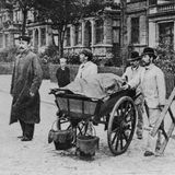 Arbeiter ziehen als Desinfektionskolonne durch die Straßen, um Häuser, Wohnungen oder Zimmer von Choleraerkrankten zu reinigen. Manchmal werden auf diesem Wege Besitztümer gestohlen.