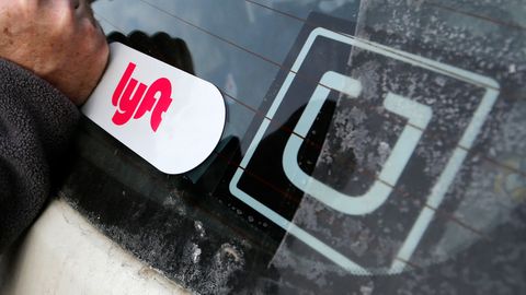 Ein Lyft-Logo ist auf dem Auto eines Lyft-Fahrers neben einem Uber-Aufkleber angebracht