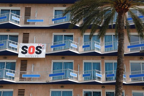 Ein Transparent mit der Aufschrift "SOS Hoteles" hängt an der Fassade eines Hotels auf Mallorca.