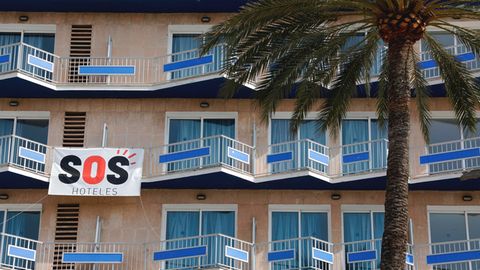 Ein Transparent mit der Aufschrift "SOS Hoteles" hängt an der Fassade eines Hotels auf Mallorca.